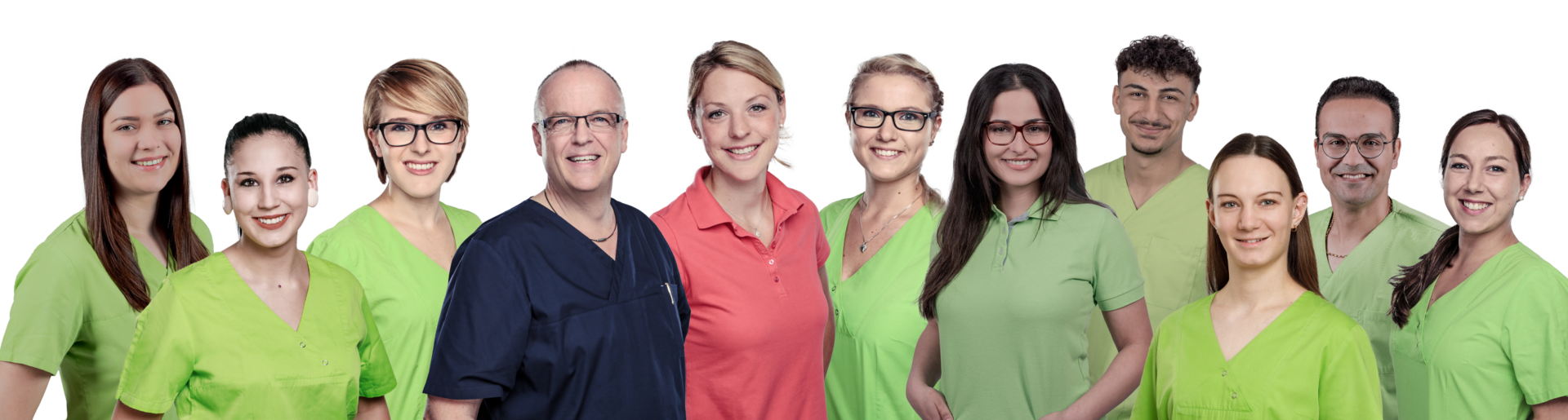 Group of ten healthcare professionals smiling at the camera, wearing green scrubs with one in navy scrubs and two in pink tops, posed together as a team.